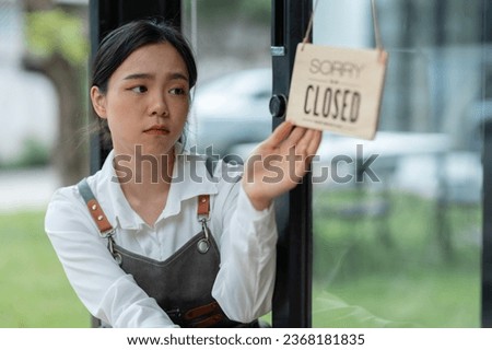 An Asian barista is stressed and bored because the economy has caused a sharp drop in coffee shop sales. Impact of small business startup business ideas