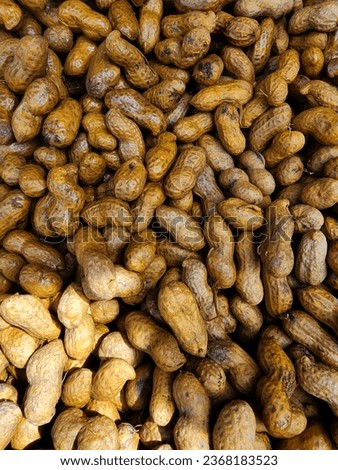 The picture shows a pile of boiled peanuts and placed on the table for sale.
