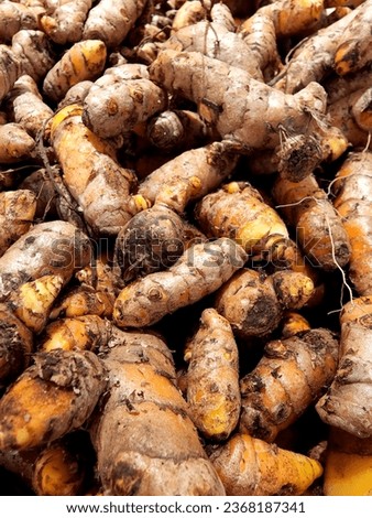 The picture shows a pile of fresh ginger on the table.