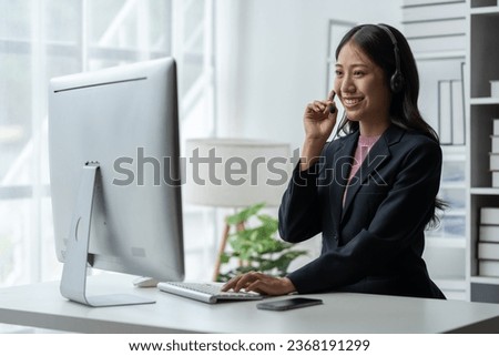 Asia call center with headset and microphone working on laptop Female entrepreneurs serving customers, business information, inquiries Support call center representatives help customers. Royalty-Free Stock Photo #2368191299