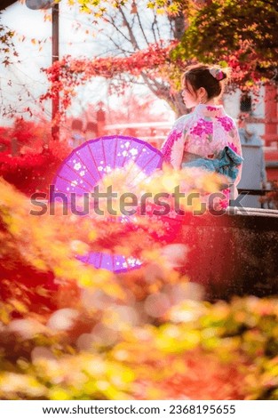 The young Asian girl was excited to wear traditional Japanese Kimono and take photos with the beautiful autumn scenery at Kiyomizudera Temple and Gion old town.