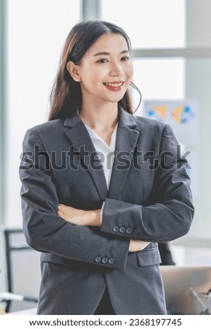 Portrait shot of Asian professional successful female businesswoman manager entrepreneur in formal suit standing smiling looking at camera in company meeting room