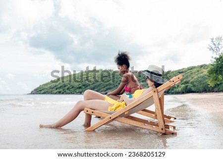 Happy beauty woman in bikini sitting and playing together on the beach having fun in a sunny day, Beach summer holiday sea people concept.