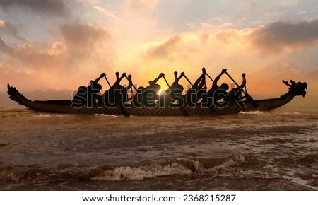 Silhouette of competitive people rowing dragon boat at sunset