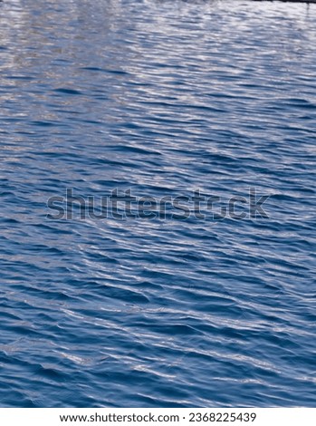 Tranquility of the sea: Photo of sea ripples and light waves creating an atmosphere of peace and harmony.Blue waves without wind create a calm pattern photo for design