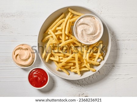 french fries with various dip sauces on white wooden table, top view Royalty-Free Stock Photo #2368236921