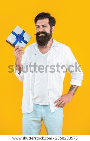cheerful man with gift box isolated on yellow. man with gift box in studio. man with gift box