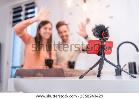 Influencers waving while recording video with phone for social media network