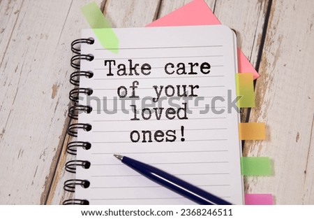 Doctor holding a card with text TAKE CARE OF YOURSELF AND YOUR LOVED ONES in both hands. Medical concept,