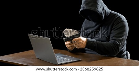Portrait hacker spy man one person in black hoodie sitting on table looking computer laptop used login password attack security to data digital internet network system night dark background copy space