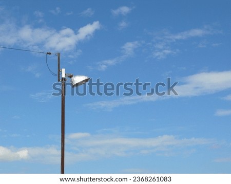 A simple street light and a wire that supplies power to it in open area.
This picture was taken for use as a background.
A blue sky is to be used as a background.
