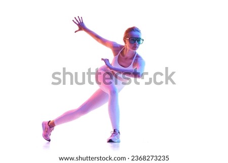 Rear view of slim girl dressed fashion outfit with sunglasses doing exercises for legs in neon light over white background. Concept of active lifestyle, sport, health, competition. Copy space