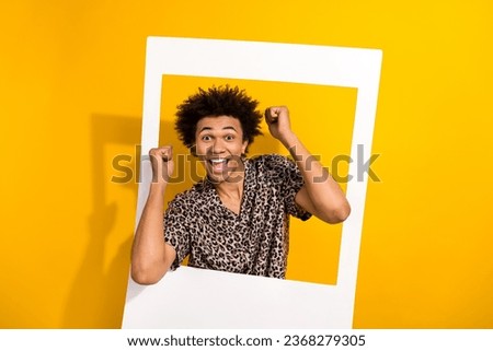 Portrait of satisfied crazy person with chevelure wear leopard shirt posing in frame win lottery isolated on yellow color background