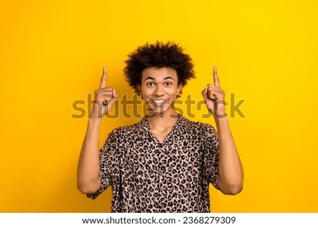 Photo optimistic student happy traveler indicate fingers above head useful tips how save money tourists isolated on yellow color background