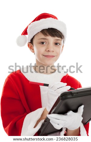 Cute 10 year old boy dressed in Santa costume making a Christmas list isolated on a white background