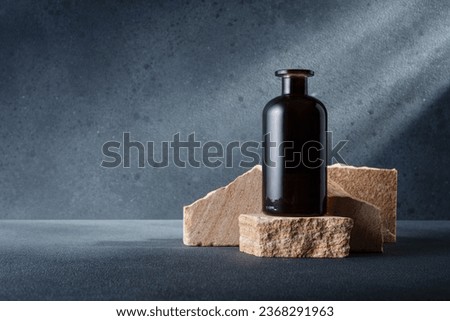 Brown glass bottle for aroma diffuser or other on the stone podium for mock-up and branding Royalty-Free Stock Photo #2368291963