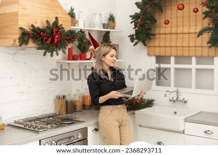 Blonde girl freelancer sitting at home in the loft kitchen with a laptop. Concept girl blonde who forgot about the deadline on New Year's Eve. holiday atmosphere