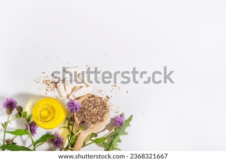 Milk Thistle supplies, powder and oil. Silybum marianum, natural organic wild flower superfood product - whole and grain seeds, pills, oil with fresh thistle flowers Royalty-Free Stock Photo #2368321667