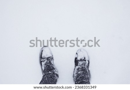 Winter coming concept. Top view of feet in a deep snowdrift. The time of year is winter. Royalty-Free Stock Photo #2368331349