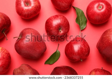 Ripe red apples and green leaves on color background, flat lay