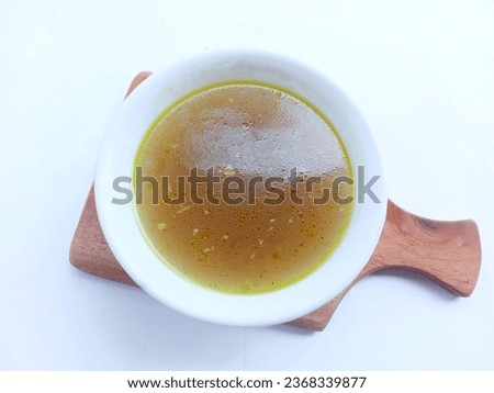 Homemade chicken stock served in a white bowl on a white background. soup full of flavour. top view