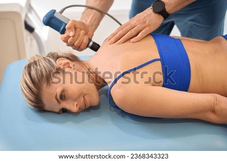 Male doctor making trigger point therapy to woman on massage couch Royalty-Free Stock Photo #2368343323