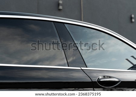 Exterior of executive luxury car of black color with tinted windows standing at parking outdoors. Modern design of expensive automobile Royalty-Free Stock Photo #2368375195