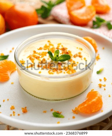 Tangerine mousse served in a glass decorated with fresh fruit and nuts. Royalty-Free Stock Photo #2368376899