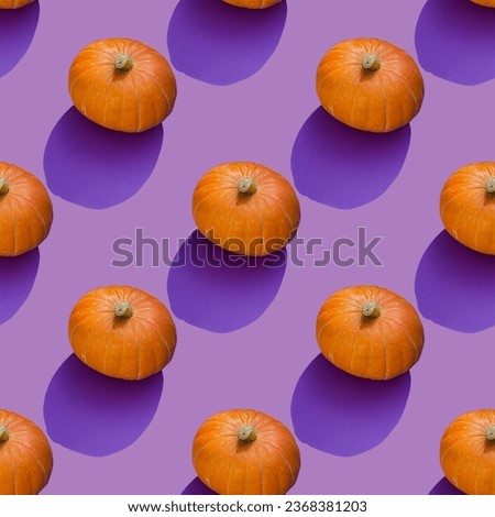Repeating pattern of orange pumpkin on a purple background. Autumn concept.