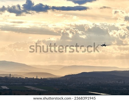 Dramatic sunlight over the city. Avram Iancu airport runway in Cluj with plane landing. East side view of Cluj Napoca, Romania. Passenger plane is landing during a wonderful sunset. Royalty-Free Stock Photo #2368391945