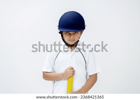 Portrait of kid holding cricket bat and looking towards the camera with attitude , Cricket concept