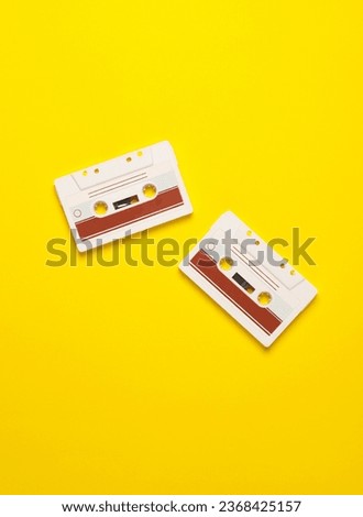 Retro 80s audio cassettes on yellow background. Music concept, vintage technology. Top view