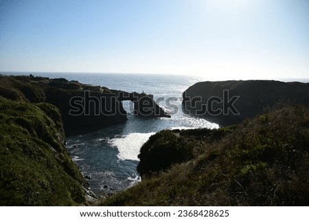 beautiful natural rock arch on the Pacific ocean with very bright blue water