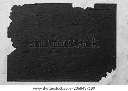 Old torn black street poster. Royalty-Free Stock Photo #2368437189