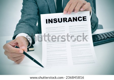 a young man in suit in his office showing an insurance policy and pointing with a pen where the policyholder must to sign Royalty-Free Stock Photo #236845816