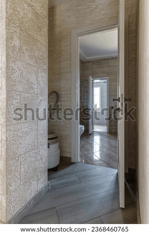 Interior of an unfinished bathroom with freshly laid ceramic tiles.