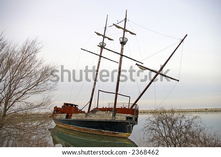 A sailing ship wrecked in a shallow lagoon