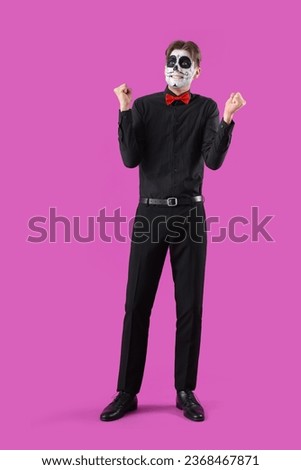 Happy young man dressed for Halloween on color background