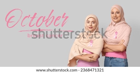Muslim women with pink ribbons on grey background. October is breast cancer awareness month