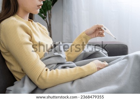 Young Asian woman having high fever while checking body temperature, female sneezing and runny nose with seasonal influenza, allergic, digital thermometer, virus, coronavirus, illness, respiratory
 Royalty-Free Stock Photo #2368479355