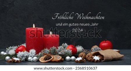 Christmas card: Festive Christmas decoration with candles and Christmas balls in the colour red and black. German inscription means translated text Merry Christmas and a Happy New Year 2024.