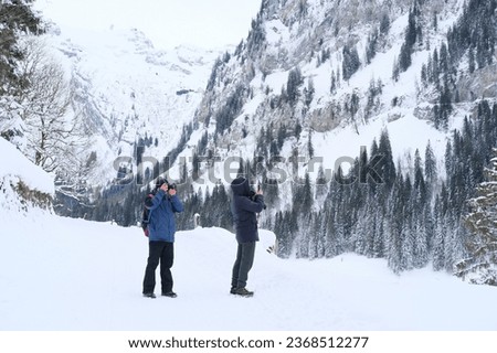 couple two man, father and son walk in the mountains, taking pictures, winter landscape, beautiful winter natural landscape, walks in winter white forest