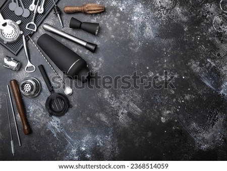 Black matt steel shaker,pourer,spoon,strainer,muddler and jigger on light bsckground.Top view. Royalty-Free Stock Photo #2368514059