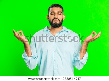 Keep calm down, relax, rest. Concentrated happy Indian man meditating breathes deeply with mudra yoga gesture, eyes closed, peaceful mind, taking a break. Arabian guy on green chroma key background