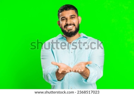Free gifts and presents for you. Indian man opening hands, excitement, preparing surprise, sharing love emotions, congratulating, charity donation. Arabian guy isolated on green chroma key background