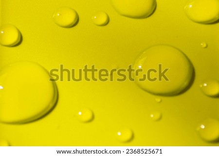 Accumulation of water drops of different sizes on a light green background.