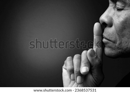  man praying to god on grey black background with people stock image stock photo	