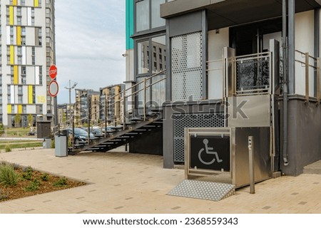 Wheelchair elevator. The special elevator for the person with a physical disabilities. Living house entrance equipped with special lifting platform for wheelchair users stock photo. Disability stairs 