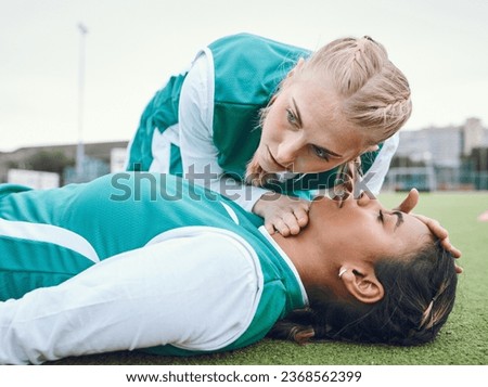 First aid, cpr and breathing with a hockey player on a field to save a player on her team after an accident. Fitness, emergency and heart attack with a woman helping her friend on a field of grass Royalty-Free Stock Photo #2368562399