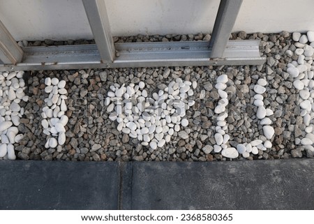 The "I love you" symbol, made of white decorative stones, arranged neatly on the floor